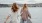 two women walking on a dock